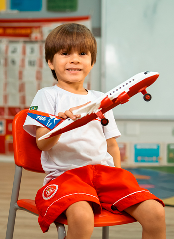 Menino feliz brincando com aviãozinho