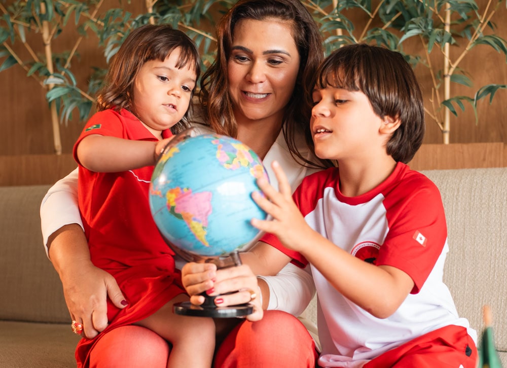 Mãe e filhos brincando com o globo giratório